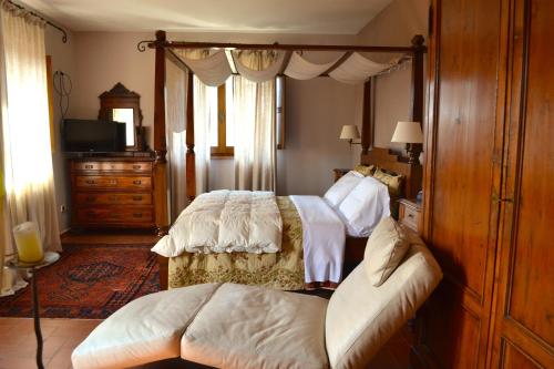 a bedroom with two beds and a couch in it at Relais Ciavatta Country Hotel in Montemerano