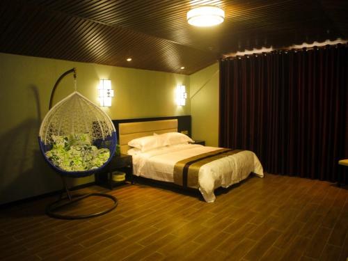 a bedroom with a large bed and a fan at GreenTree Alliance Texas Ningjin County Zhengyang Road Debai Plaza Hotel in Dezhou
