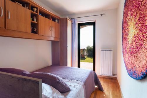 a bedroom with a bed and a large window at Villa EMI in Zgornje Škofije