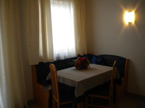 a table with a flower arrangement on it in front of a window at Haus Helene in Rauris