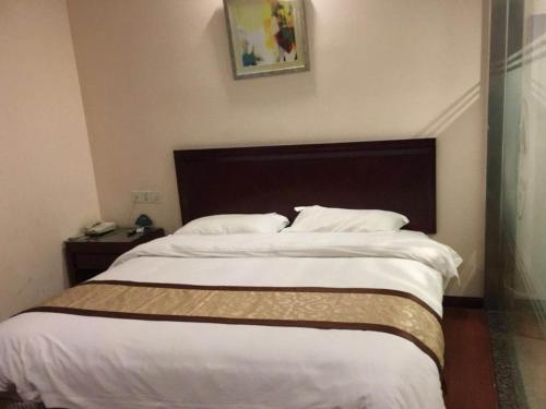 a bedroom with a large bed with white sheets at GreenTree Inn Jiangsu Suzhou International Education Zone Shihu Express Hotel in Suzhou