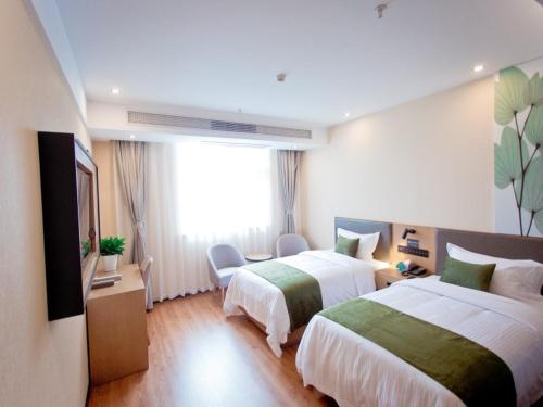 a hotel room with two beds and a window at GreenTree Inn Fuyang City Yingzhou District Kuixing Road Business Hotel in Fuyang