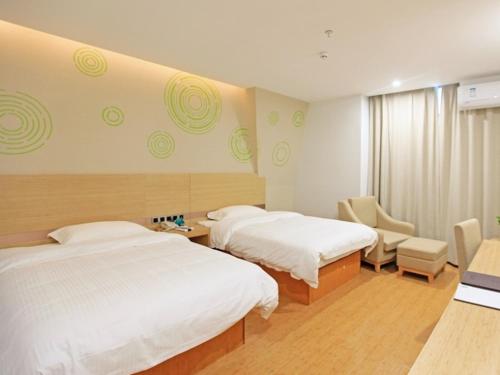 a hotel room with two beds and a chair at GreenTree Inn Anqing Duxiu Avenue Greenland Metropolis Express Hotel in Anqing