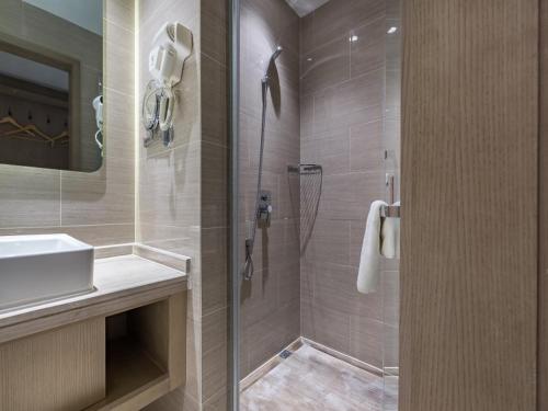 a bathroom with a shower and a sink at GreenTree Eastern Xuzhou High Speed Railway Station West Exit Station Hotel in Xuzhou