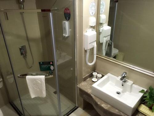 a bathroom with a shower and a sink and a sink at GreenTree Inn Jiangsu Xuzhou Food Town International Exhibition and Convention Center Business Hotel in Xuzhou