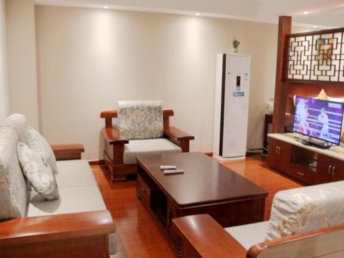 a living room with a couch and a refrigerator at GreenTree Inn ShanXi ChangZhi Bus Passenger Station XiHuan Road Business Hotel in Changzhi