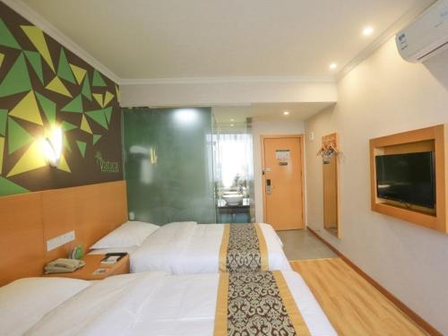 a hotel room with two beds and a flat screen tv at Vatica Hefei Lujiang Road Hotel in Hefei