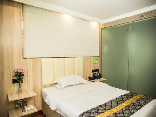 sypialnia z dużym łóżkiem i oknem w obiekcie GreenTree Inn Jinhua Railway Station Express Hotel w mieście Jinhua