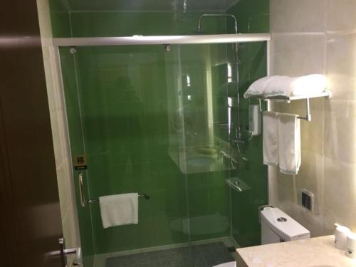 a bathroom with a glass shower with a toilet at GreenTree Inn Beijing Tongzhou District Yujiawu Technology park Express Hotel in Tongzhou