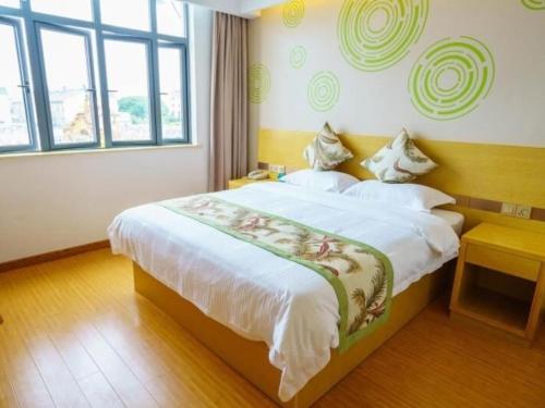 ein Schlafzimmer mit einem großen Bett und einem großen Fenster in der Unterkunft GreenTree Inn Suzhou Mudu Lingyan Mountain Ganglong City Hotel in Suzhou