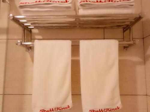 two towels are hanging on a rack in a bathroom at Shell Shangrao Qianshan County North Longmen Road Hotel in Yanshan