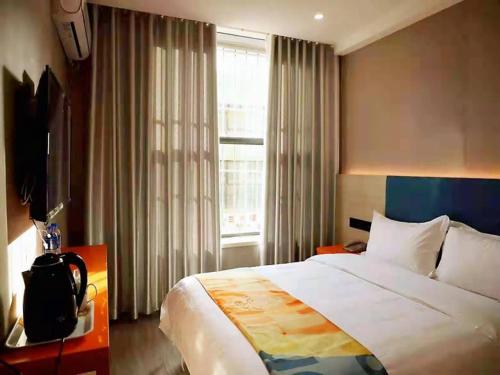 a bedroom with a large bed and a window at Shell Lanzhou Qilihe District Lanzhou High Speed Railway Station Hotel in Lanzhou