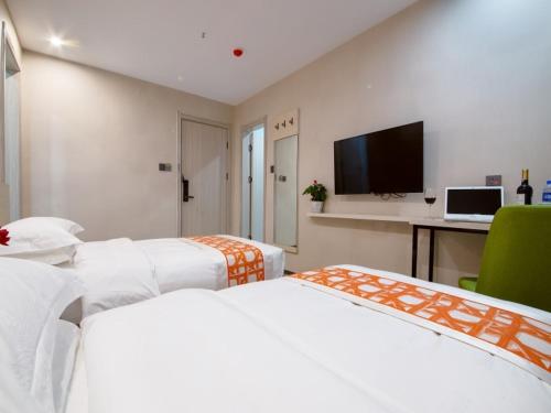 a hotel room with two beds and a television at Shell Xi'an Yanta District Jixiang Village Subway Entrance Hotel in Xi'an