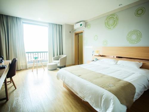 a bedroom with a large bed and a large window at GreenTree Inn Zhoushan Baiquan Colorful Plaza Express Hotel in Zhoushan
