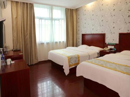 BalipuにあるGreenTree Inn Anhui Fuyang Taihe South Xiyang Road Business Hotelのベッド2台と窓が備わるホテルルームです。