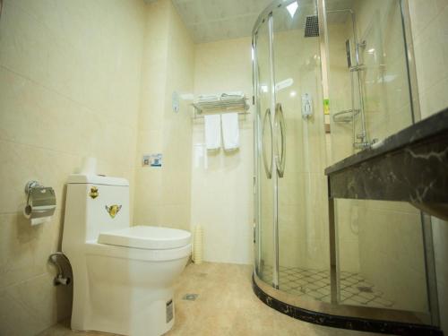 a bathroom with a glass shower and a toilet at GreenTree Inn Zhoushan Baiquan Colorful Plaza Express Hotel in Zhoushan