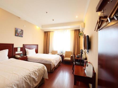 um quarto de hotel com duas camas e uma televisão em GreenTree Inn Hefei Maanshan Road Qiupuhe Road Subway Station Business Hotel em Hefei