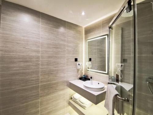a bathroom with a sink and a mirror at Gya Taizhou Jingjiang City South Century Plaza Hotel in Jingjiang