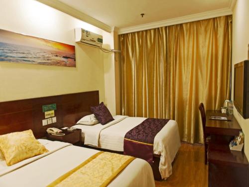 a hotel room with two beds and a television at GreenTree Inn Tianjin Huanghe Ave Guangkai Metro Station Express Hotel in Tianjin