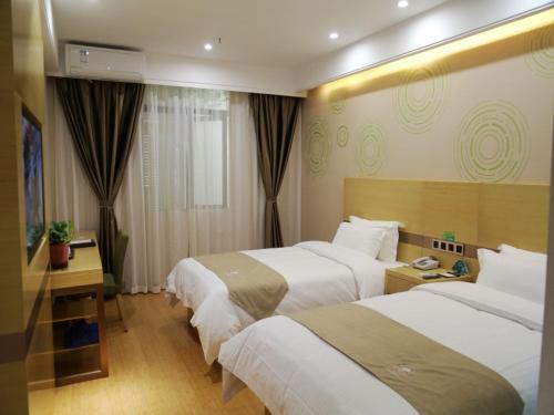 une chambre d'hôtel avec trois lits et une télévision dans l'établissement GreenTree Inn Hefei City Baohe DistrictGarden Avenue Express Hotel, à Hefei