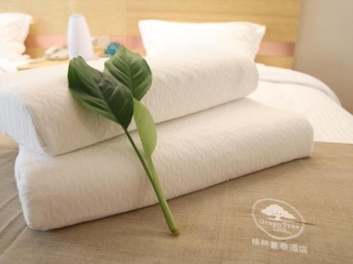 a plant sitting on top of a pile of towels at GreenTree Inn Xuzhou Ou Shasha Building Materials City Express Hotel in Xuzhou