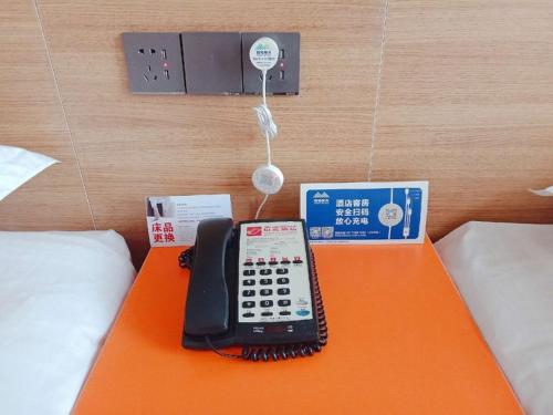 a phone on an orange table in a hotel room at Shell Tai'an Taishan District Xinhuacheng International Plaza Hotel in Tai'an