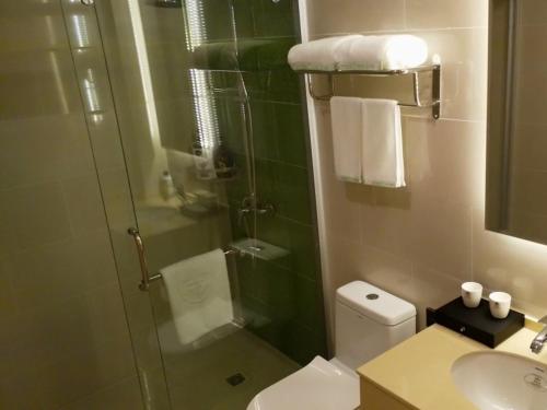 a bathroom with a shower and a toilet and a sink at GreenTree Inn HuaiAn Area for development Shenzhen East Road Express Hotel in Huai'an