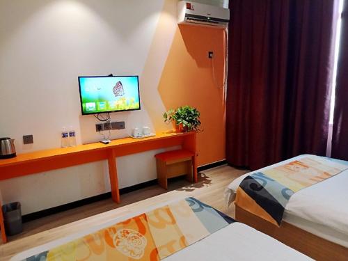a hotel room with a desk with a television on it at Shell Tai'an Taishan District Xinhuacheng International Plaza Hotel in Tai'an