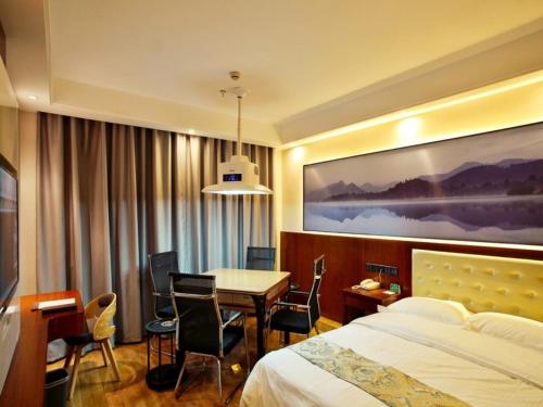 a hotel room with a bed and a table and chairs at GreenTree Alliance Changzhou Jintan District Dongmen Street Hotel Hotel in Changzhou