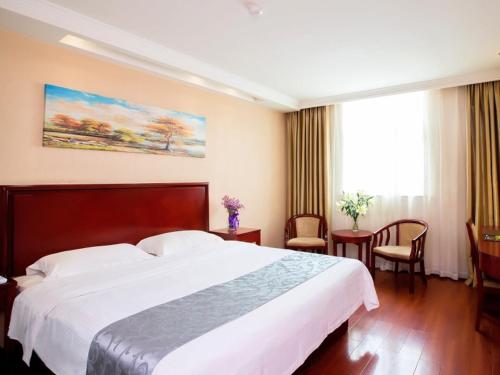 a hotel room with a large bed and a window at GreenTree Inn Henan Zhengzhou West Changjang Road Business Hotel in Zhengzhou