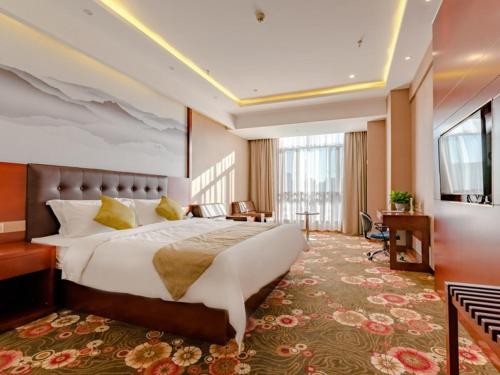 a hotel room with a large bed and a desk at GreenTree Inn Taian High-speed Railway Station Lingshan Avenue Business Hotel in Tai'an