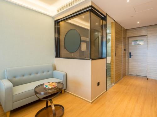a living room with a couch and a table at GreenTree Eastern Xuzhou High Speed Railway Station West Exit Station Hotel in Xuzhou