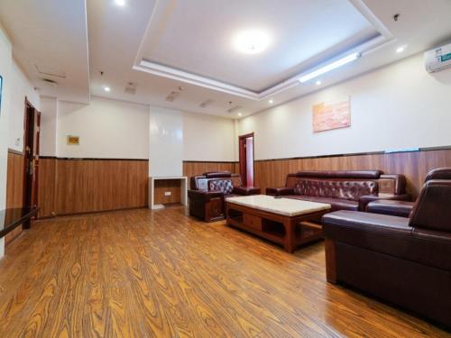 a waiting room with couches and a table in a room at GreenTree Inn Henan Zhengzhou Chengnan Road Bojue Business Hotel in Zhengzhou