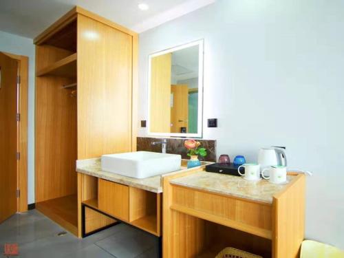 a bathroom with a sink and a mirror at GreenTree Inn Wuxi Jiangyin Changjing Town Selected Hotel in Wuxi