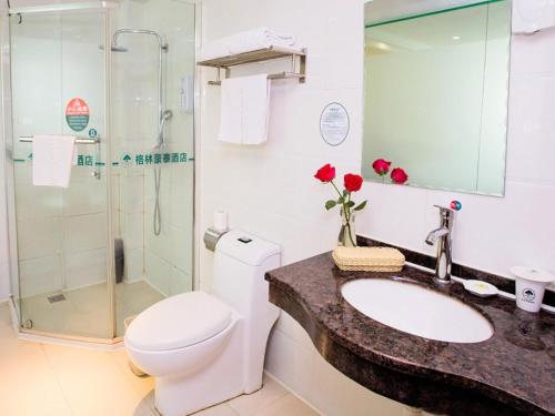 a bathroom with a toilet and a sink and a shower at GreenTree Inn Henan Zhengzhou West Changjang Road Business Hotel in Zhengzhou