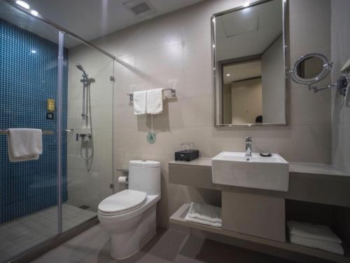 a bathroom with a toilet and a sink and a shower at GreenTree Inn Suzhou Kunshan Dongcheng Road International Exhibition Express Hotel in Penglang
