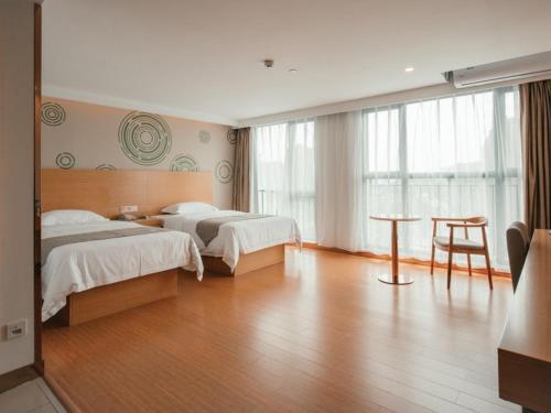 een hotelkamer met twee bedden en een tafel bij GreenTree Inn Guangxi Zhuang Autonomous Region Guilin Lingui District Luhu International Express Hotel in Guilin