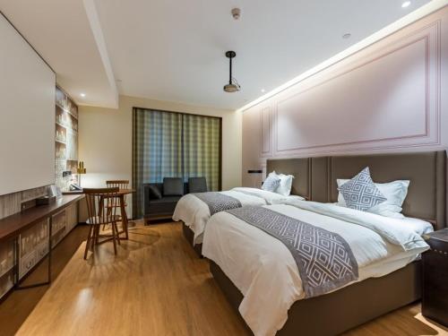 a large bedroom with a large bed and a table at GreenTree Eastern Xuzhou High Speed Railway Station West Exit Station Hotel in Xuzhou
