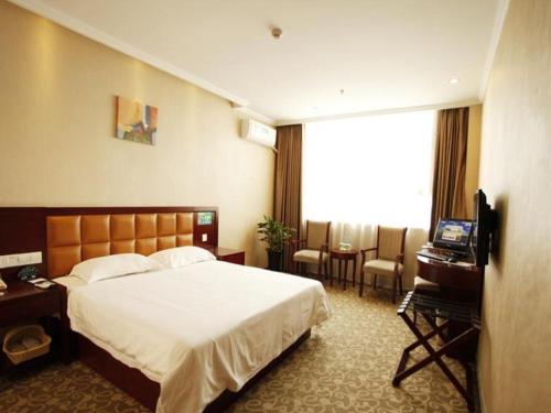 a hotel room with a bed and a television at GreenTree Inn Anhui Hefei Tianehu Wanda Square Express Hotel in Hefei