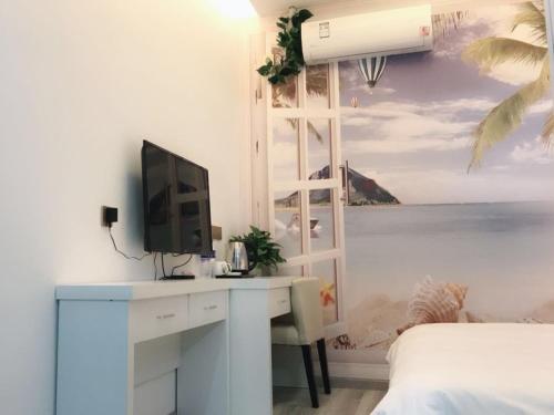 a bedroom with a desk with a computer and a window at Shell Wuxi Huishan DistrictWanda Plaza Yanqiao Subway Station Hotel in Wuxi