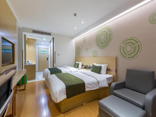 a bedroom with a bed and a couch and a television at GreenTree Eastern Xuzhou High Speed Railway Station West Exit Station Hotel in Xuzhou