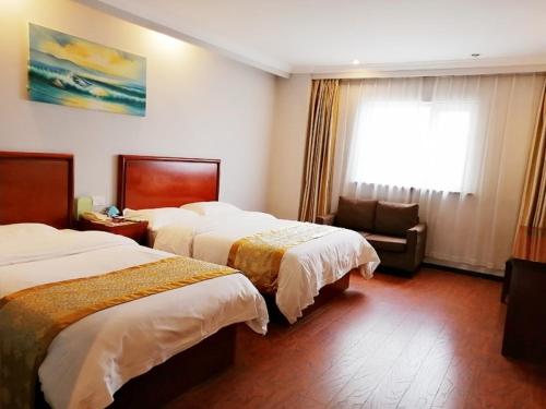a hotel room with two beds and a window at GreenTree Inn Shanghai Meilan Lake Hutai Road Express Hotel in Baoshan