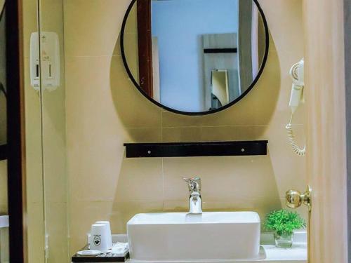 a bathroom with a sink and a mirror at GreenTree Inn Anhui Xuancheng South Zhuangyuan Road Express Hotel in Xuanzhou