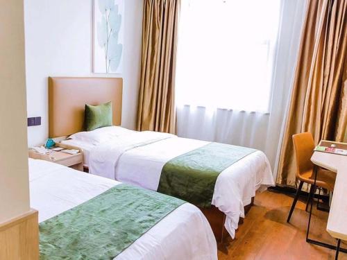 a hotel room with two beds and a desk at GreenTree Inn Anhui Xuancheng South Zhuangyuan Road Express Hotel in Xuanzhou