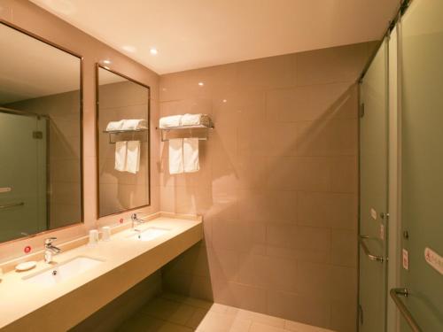 a bathroom with two sinks and a shower at GreenTree Inn Wuxi Rongchuang cultural Tourism City Nanquan Town Business Hotel in Wuxi