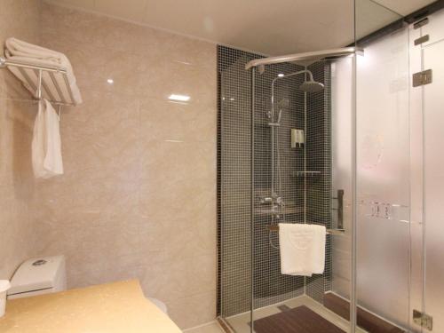 a bathroom with a shower with a glass door at GreenTree Inn JiangSu ZHenjiang Jurong Yalong Business Hotel in Jurong