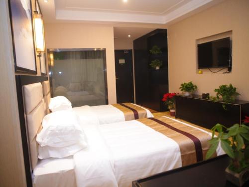 a hotel room with two beds and a television at GreenTree Alliance Texas Ningjin County Zhengyang Road Debai Plaza Hotel in Dezhou