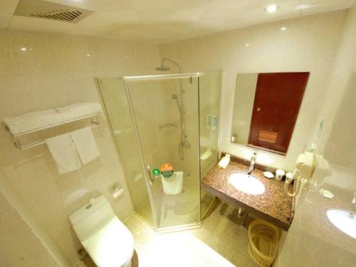 a bathroom with a shower and a toilet and a sink at GreenTree Inn Jiangsu Taizhou Jingjiang Bus Station Express Hotel in Jingjiang