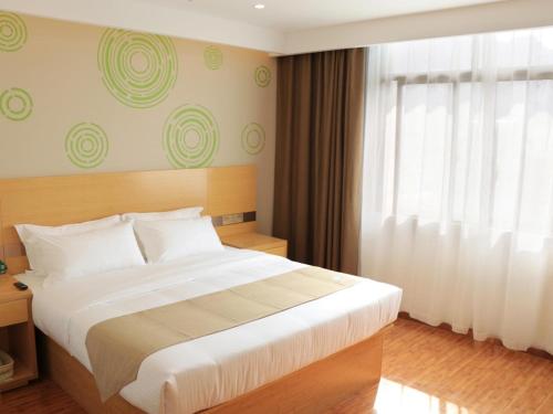 um quarto com uma cama grande e uma janela em GreenTree Inn Huangshi Huahu Development Zone Daquan Road Business Hotel em Huangshi