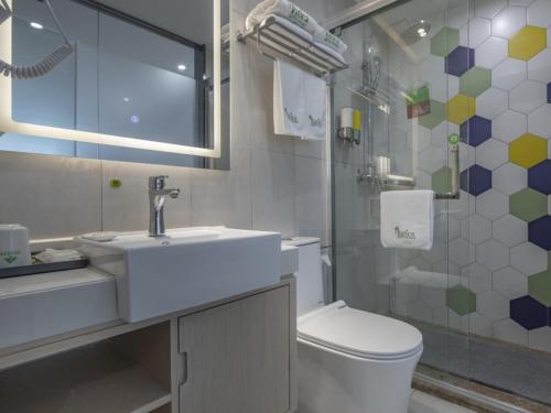 y baño con lavabo, aseo y ducha. en Vatica Hefei Huangshan Road Yuexi Road Hotel en Hefei